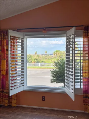 a view of a livingroom with wooden floor and a window
