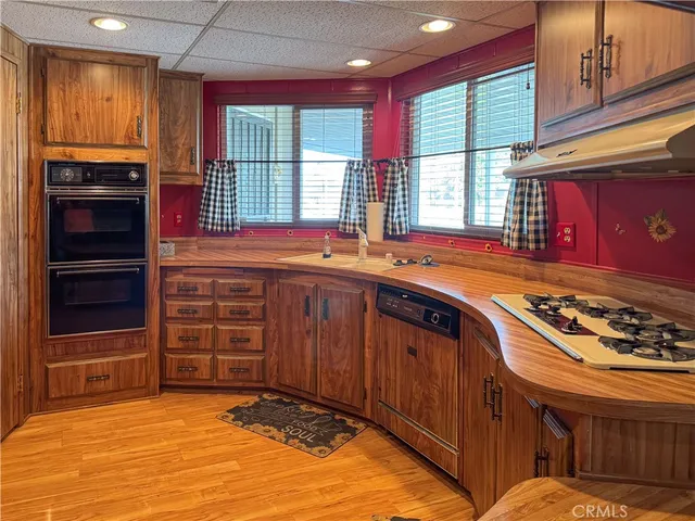 a kitchen with stainless steel appliances granite countertop wooden cabinets and a sink