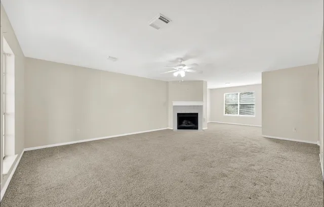 an empty room with fireplace and windows