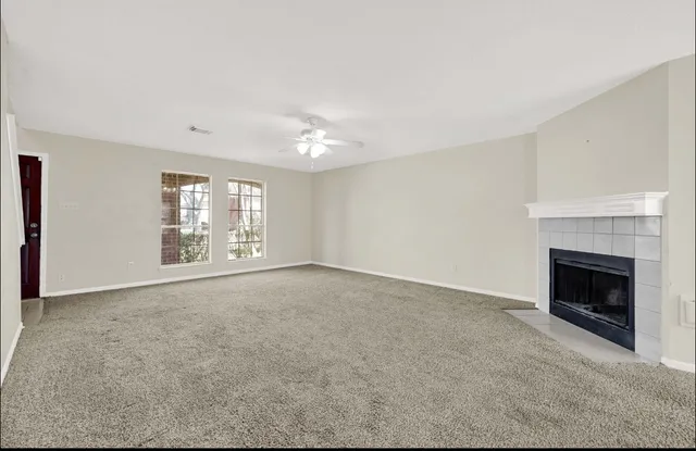 a view of an empty room with a fireplace and a window