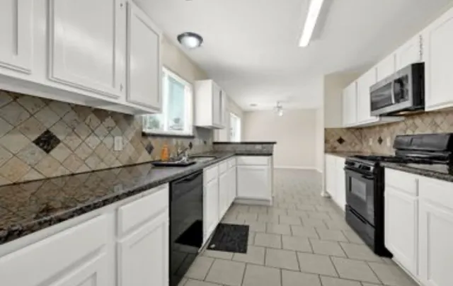 a kitchen with stainless steel appliances granite countertop a sink and a stove