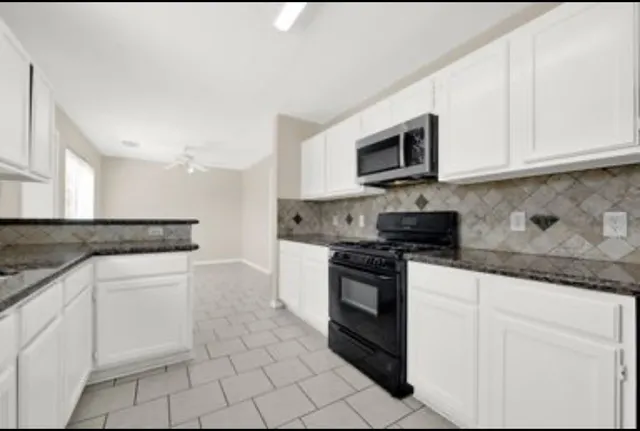 a kitchen with white cabinets stainless steel appliances and sink