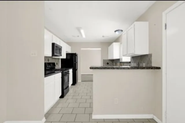 a kitchen with stainless steel appliances granite countertop a refrigerator a stove a sink and a microwave