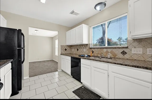 a kitchen with granite countertop a refrigerator and a sink