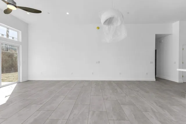 an empty room with a ceiling fan and entryway