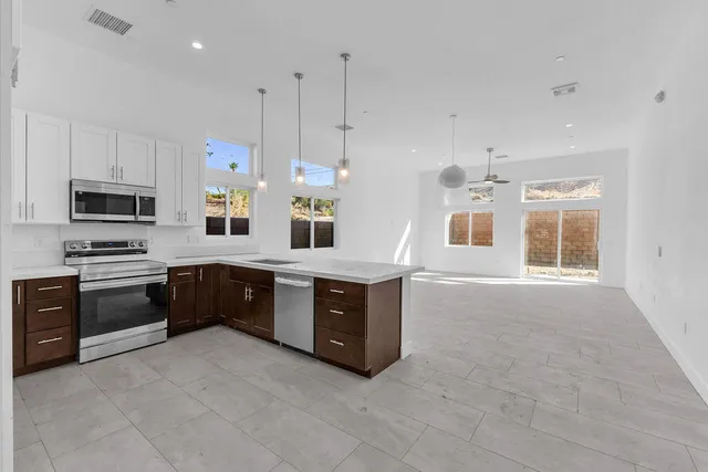a large white kitchen with kitchen island a sink a stove and a refrigerator