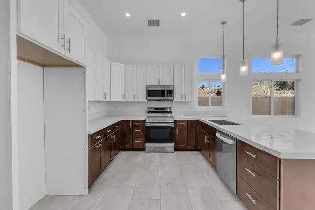 a kitchen with stainless steel appliances granite countertop a sink and a stove top oven