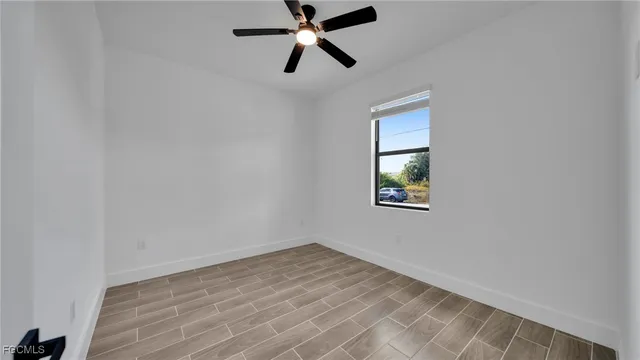 an empty room with a window and a fan
