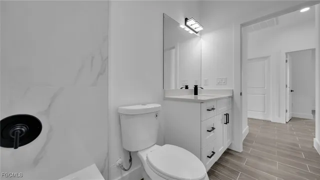 a bathroom with a sink a toilet a mirror and vanity