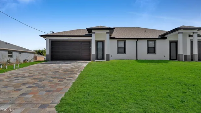 a front view of a house with a yard and garage