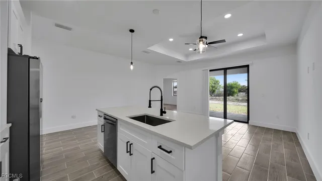 a kitchen with a sink a refrigerator and chandelier
