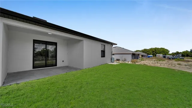 a backyard of a house with table and chairs