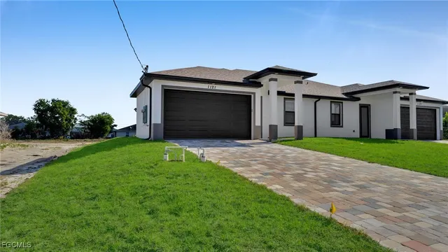 a front view of a house with a garden and yard