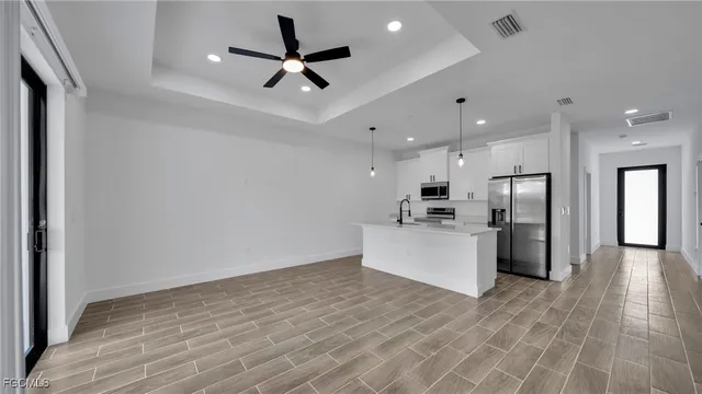 a view of a kitchen with a refrigerator and a microwave