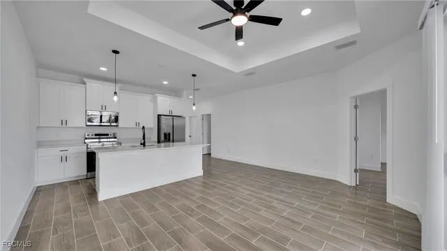 a view of kitchen with stainless steel appliances refrigerator stove microwave and cabinets