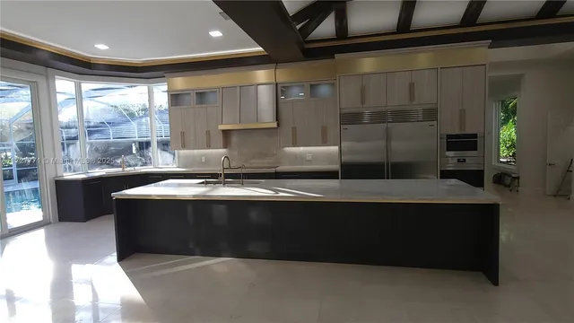 a living room with stainless steel appliances granite countertop a sink a stove and a refrigerator