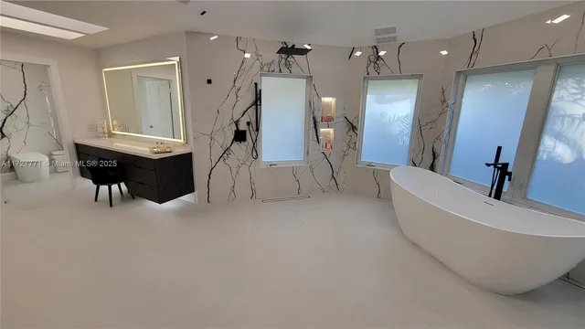 a bathroom with a bathtub and a hallway