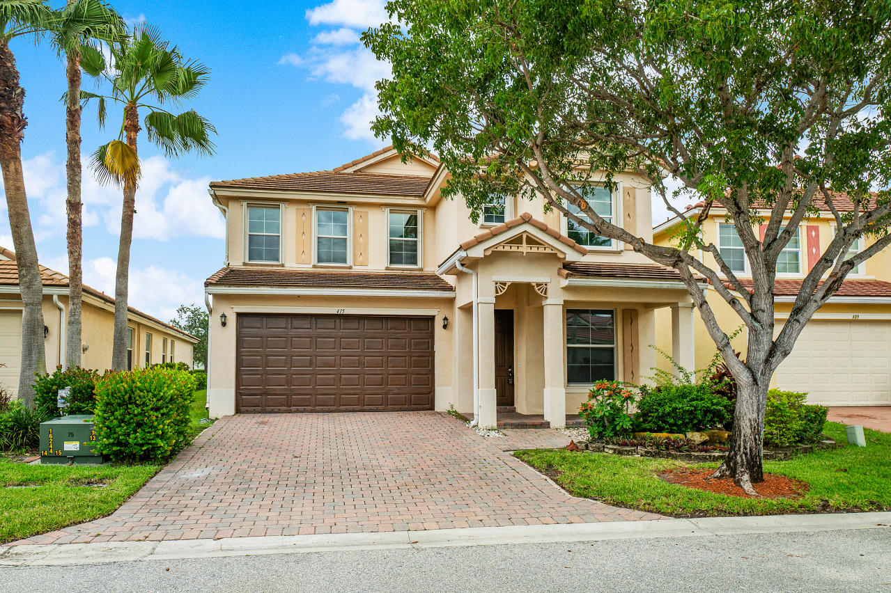 415 Mulberry Grove Road Royal Palm Beach, FL 33411 - Photo 1 of 39 a front view of a house with a garden