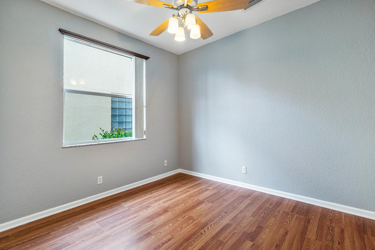 415 Mulberry Grove Road Royal Palm Beach, FL 33411 - Photo 12 of 39 an empty room with a window and wooden floor