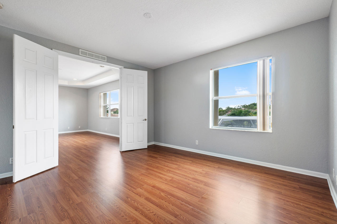 415 Mulberry Grove Road Royal Palm Beach, FL 33411 - Photo 17 of 39 a view of an empty room with wooden floor and a window