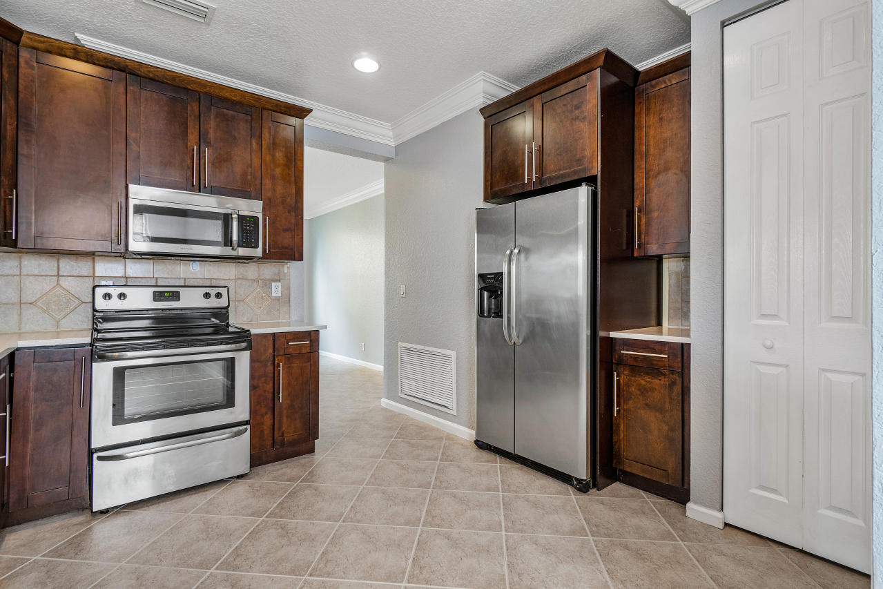 415 Mulberry Grove Road Royal Palm Beach, FL 33411 - Photo 6 of 39 a kitchen with stainless steel appliances granite countertop a refrigerator and a stove top oven
