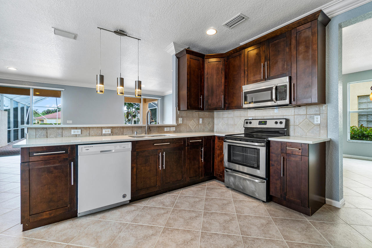 415 Mulberry Grove Road Royal Palm Beach, FL 33411 - Photo 8 of 39 a kitchen with stainless steel appliances granite countertop a stove microwave and sink