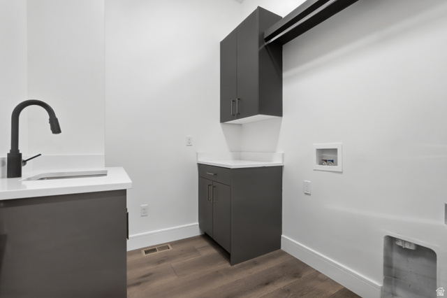 653 East Vandalay Lane Draper, UT 84020 - Photo 30 of 61 Laundry room featuring dark gray cabinetry, white countertops, a black gooseneck faucet, an integrated sink, and wood-finish flooring