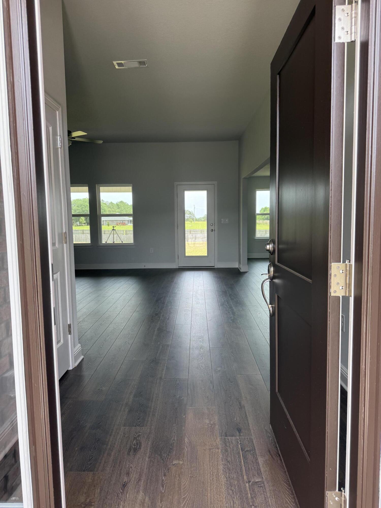 6004 Crocket Cove Crestview, FL 32539 - Photo 5 of 24 an empty room with wooden floor and windows