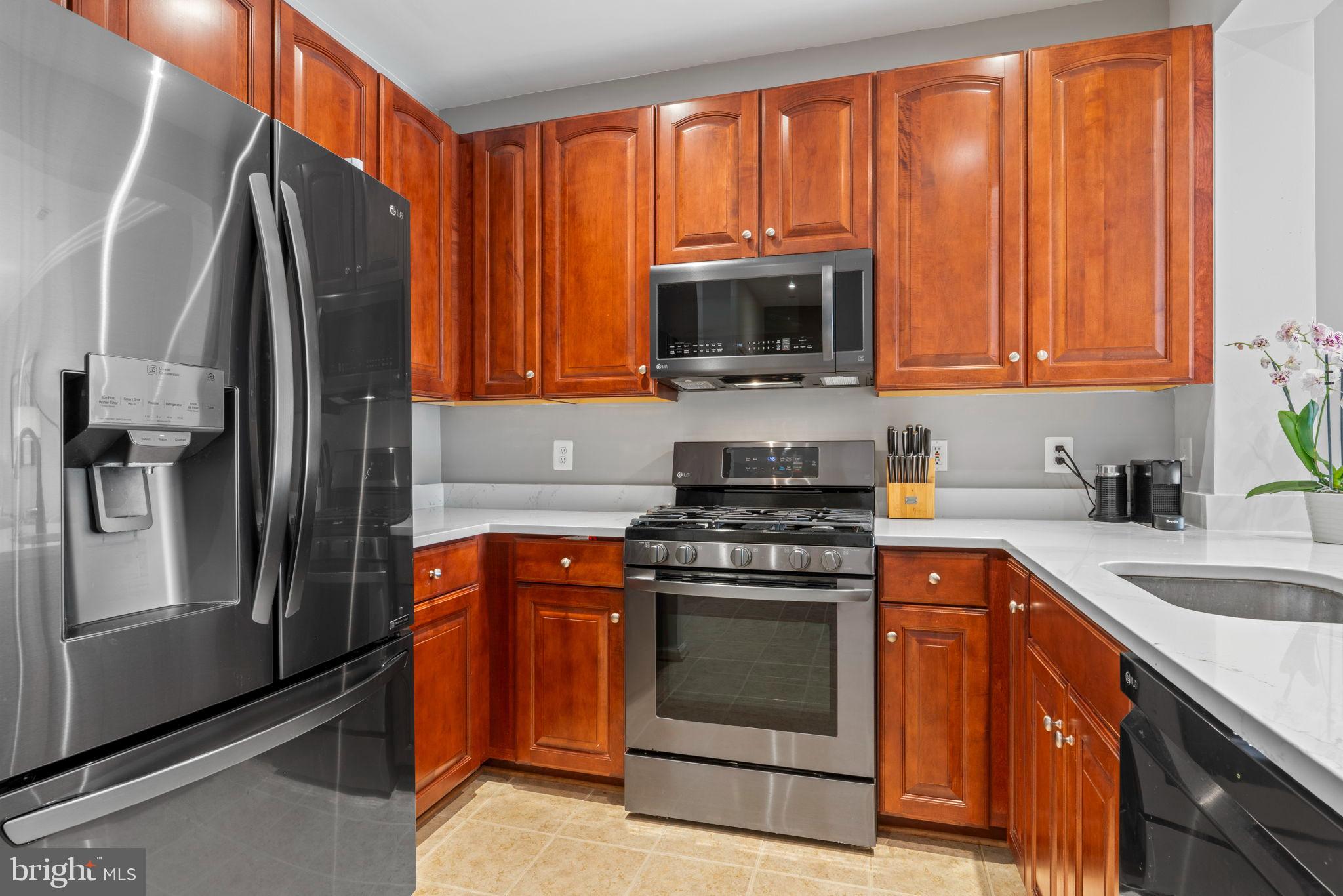12001 Market Street, Unit 319 Reston, VA 20190 - Photo 3 of 37 Kitchen with rich wood cabinetry.
