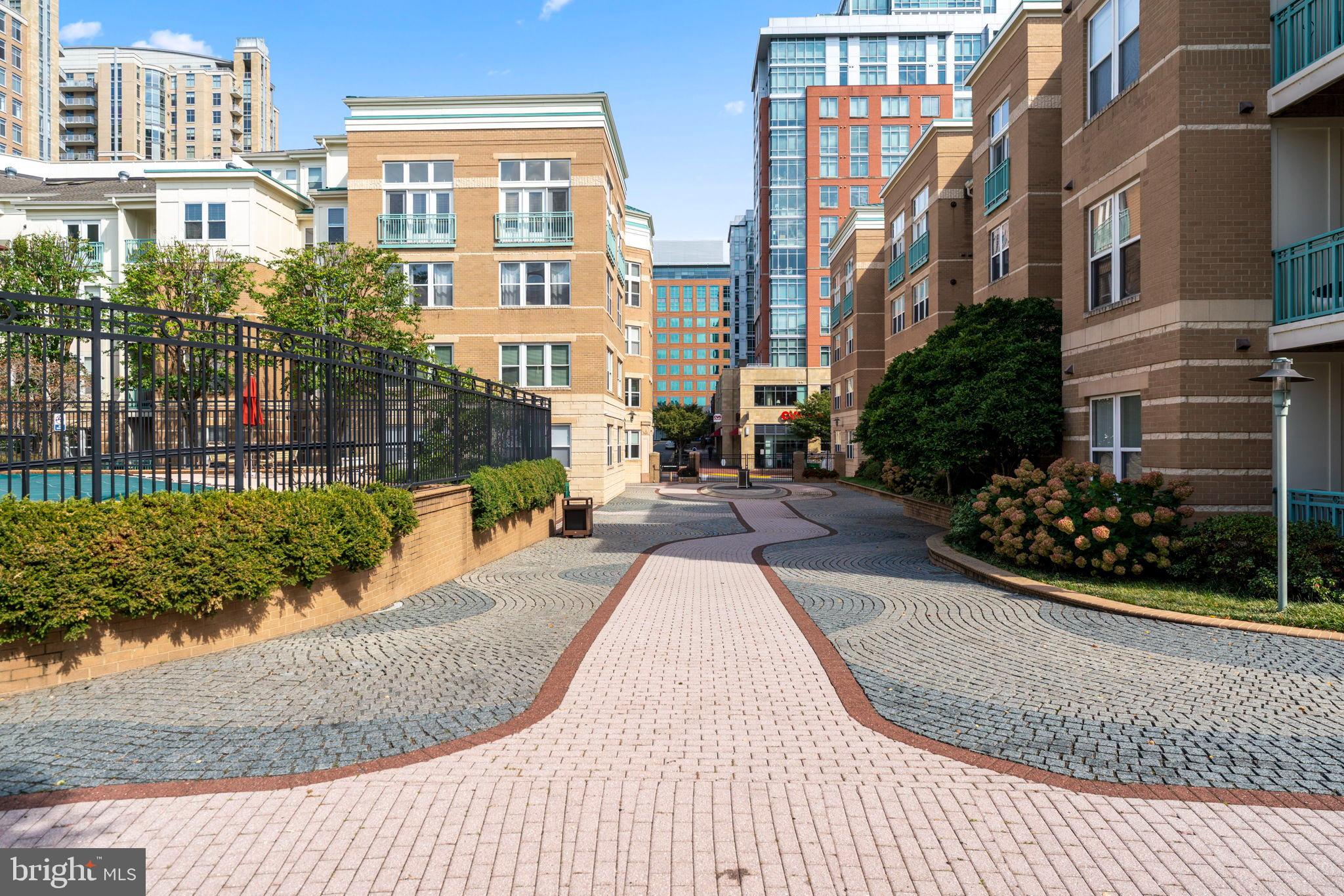 12001 Market Street, Unit 319 Reston, VA 20190 - Photo 32 of 37 Charming pathway through urban residences.