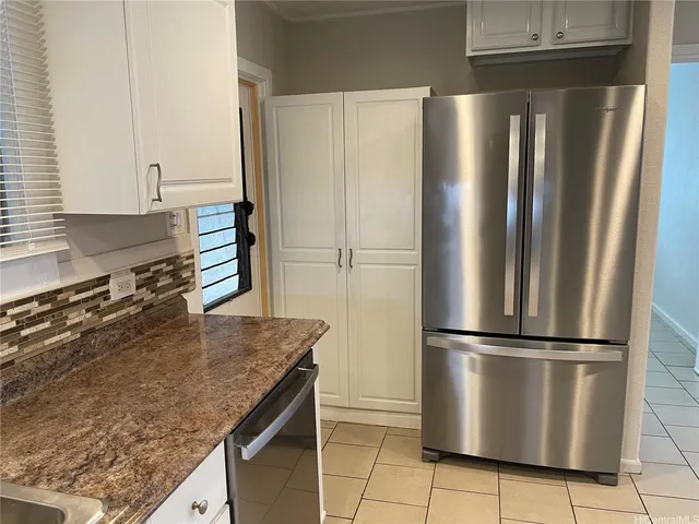 a kitchen with granite countertop a refrigerator and a sink