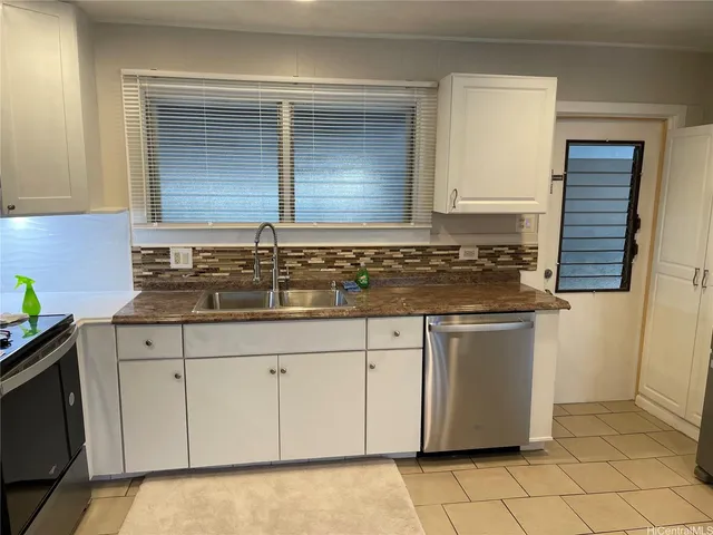 a kitchen with granite countertop a sink and a stove