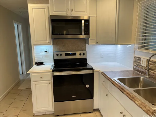 a kitchen with a stove microwave and sink