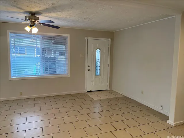 an empty room with chandelier fan