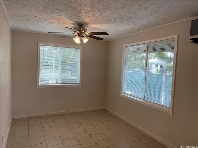 an empty room with windows and fan