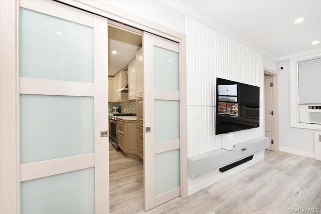 a hallway with white cabinets and stainless steel appliances