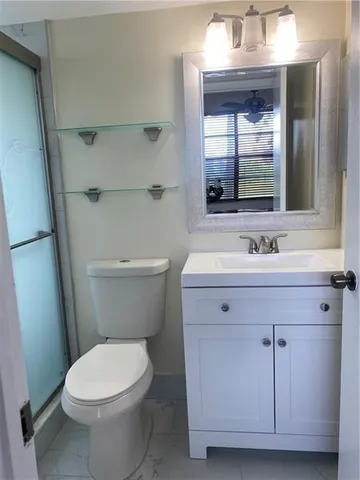 a bathroom with a sink vanity and a toilet