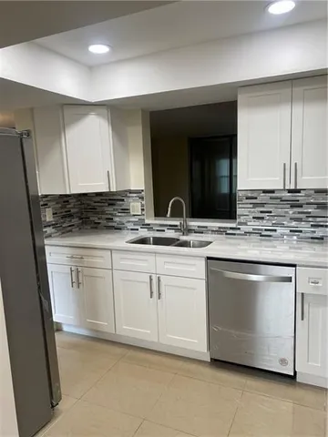 a kitchen with granite countertop white cabinets and stainless steel appliances