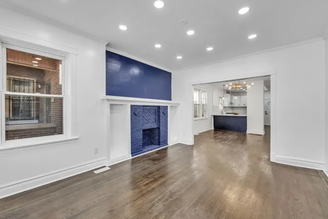 a view of empty room with fireplace and wooden floor