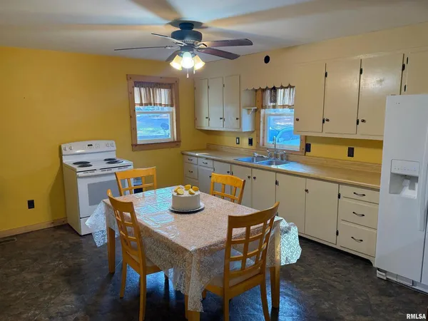 a kitchen with a table chairs and a refrigerator