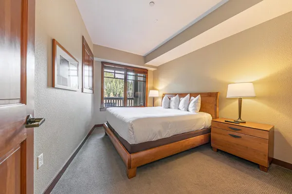 a spacious bedroom with a bed and a lamp