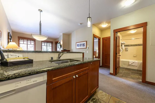 a kitchen with a refrigerator a sink and chandelier