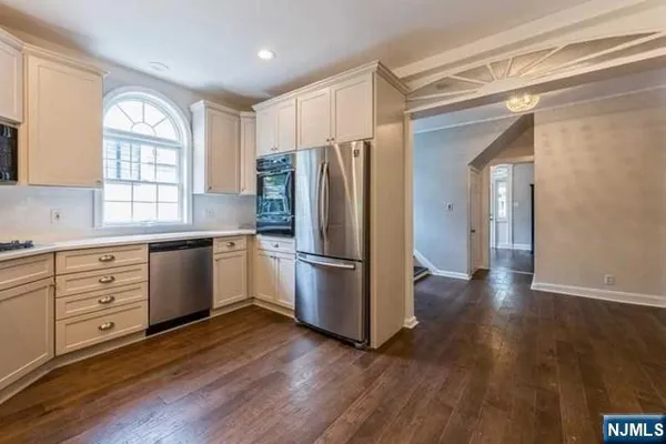 an empty room with wooden floor fireplace and windows