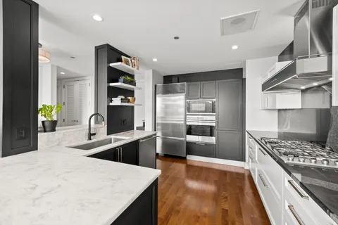 a kitchen with stainless steel appliances a refrigerator and a stove top oven