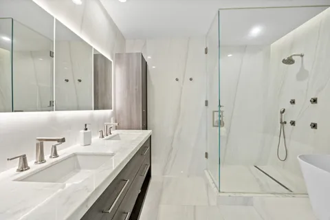 a bathroom with a granite countertop bathtub shower and toilet