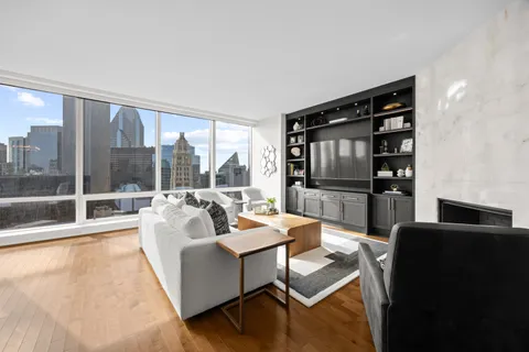 a living room with furniture tv and a floor to ceiling window