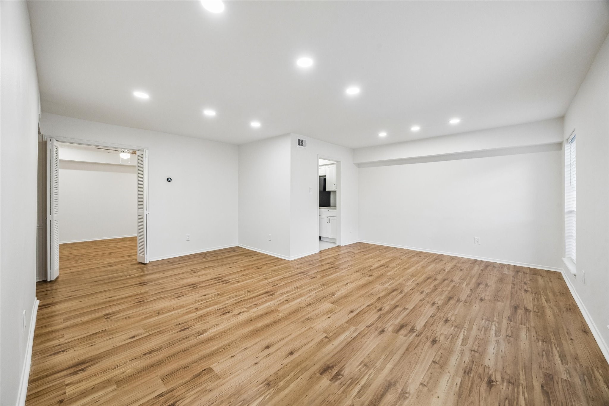357 North Post Oak Lane, Unit 102 Houston, TX 77024 - Photo 3 of 18 The spacious living room is open to the breakfast/dining area. A flex space can be seen on the left and the kitchen is in the background.