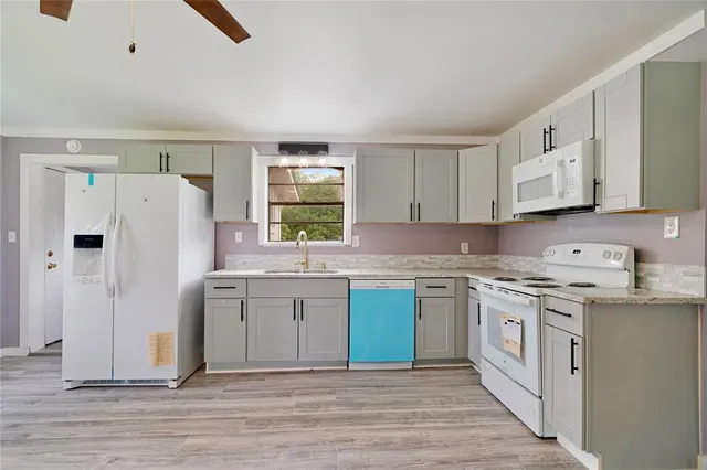 a kitchen with stainless steel appliances granite countertop a stove a sink and a refrigerator