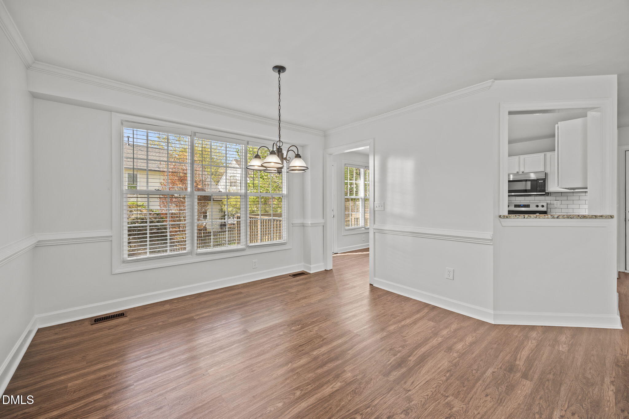 9220 Pennythorne Court Raleigh, NC 27615 - Photo 15 of 49 a view of an empty room with a window and wooden floor