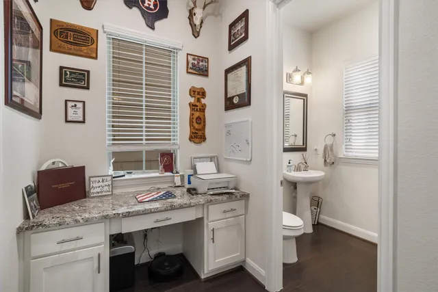 a bathroom with a granite countertop sink a toilet and a mirror